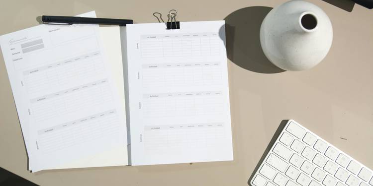 A creative workspace with a notepad, pen, and digital device illustrating the action of writing and counting words, ideal for an online word counter tool page