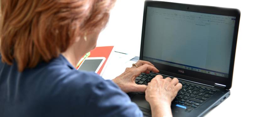 A person using an online text case converter tool, editing and formatting text on a laptop with a modern workspace